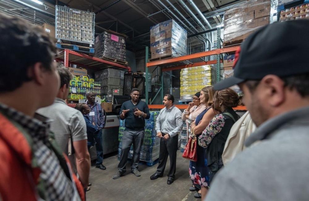 A group touring a marketplace warehouse