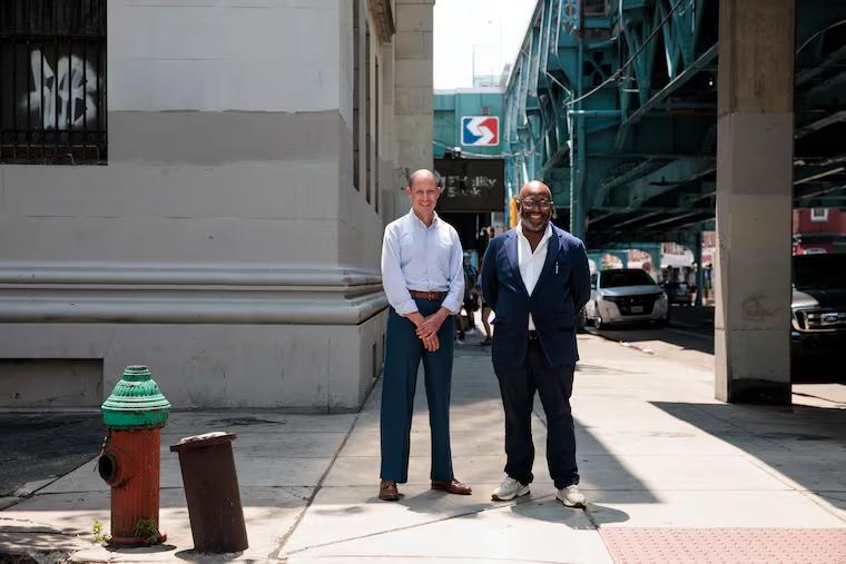 Two project leads outside the former Textile National Bank building